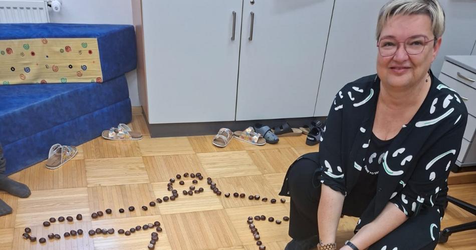 Körperumriss mit Kastanien, Lehrerin sitzt daneben auf dem Boden