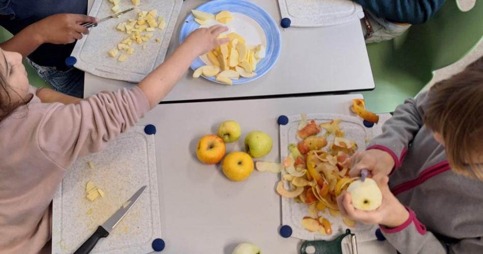 Kinder beim Äpfel schälen und klein aufschneiden